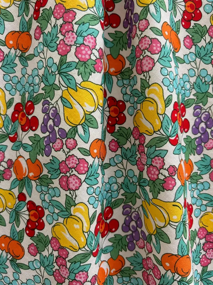 Farmer’s market floral cotton retro midi dress with pockets featuring vibrant fruit pattern on light cream background