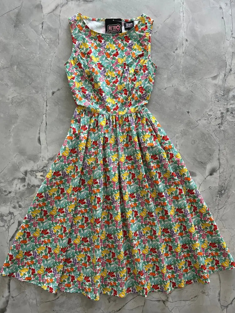 A sleeveless retro cotton midi dress with vibrant cherry and lemon floral print in light green with pockets