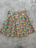 A vibrant cotton skater skirt with pleated colorful fruit and berry print on white background farmers market style