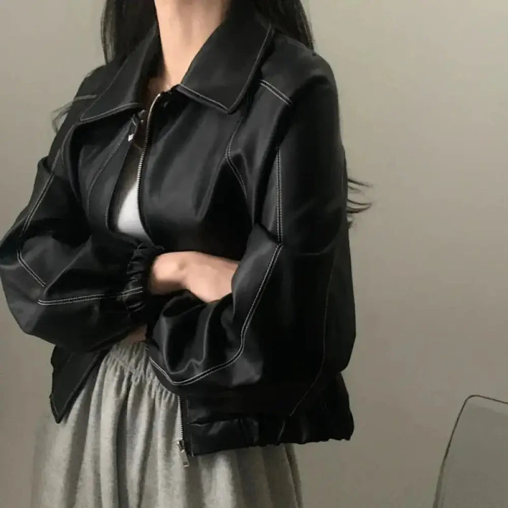 Black faux leather bomber jacket with white contrast stitching and elasticated cuffs displayed from the back side