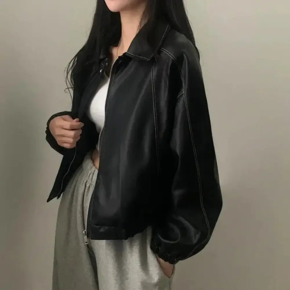 Black faux leather bomber jacket with contrast white stitching and a front zipper for stylish outerwear use