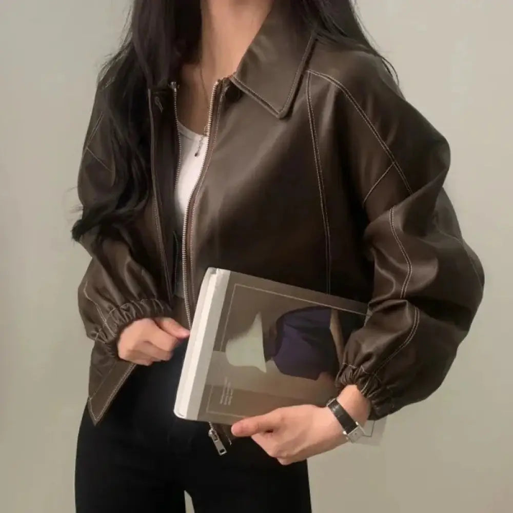 Brown faux leather bomber jacket with contrasting stitching and elastic cuffs shown from the back side