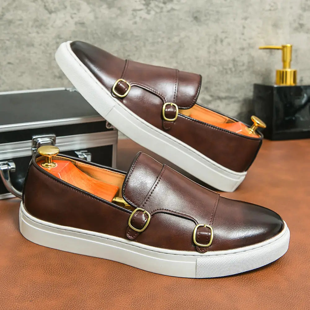 Men’s brown leather double monk strap loafers with gold-tone buckles and white rubber soles slip-on design