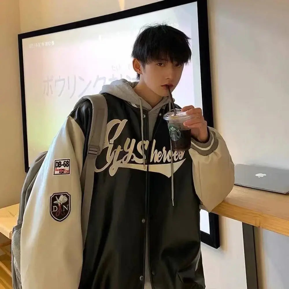 Men’s embroidered pu leather baseball bomber jacket in black and cream with embroidered lettering and patches
