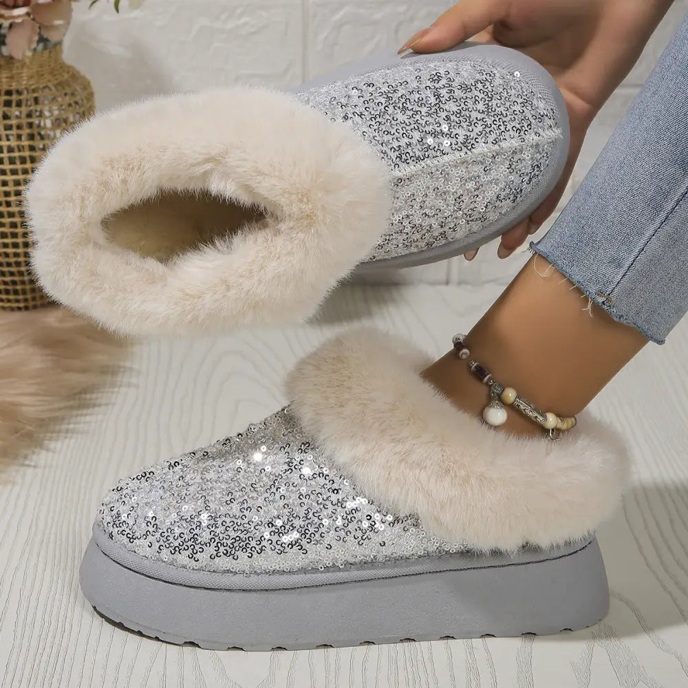 Silver sequined slip-on winter slipper boot with plush white faux fur lining and chunky gray platform sole