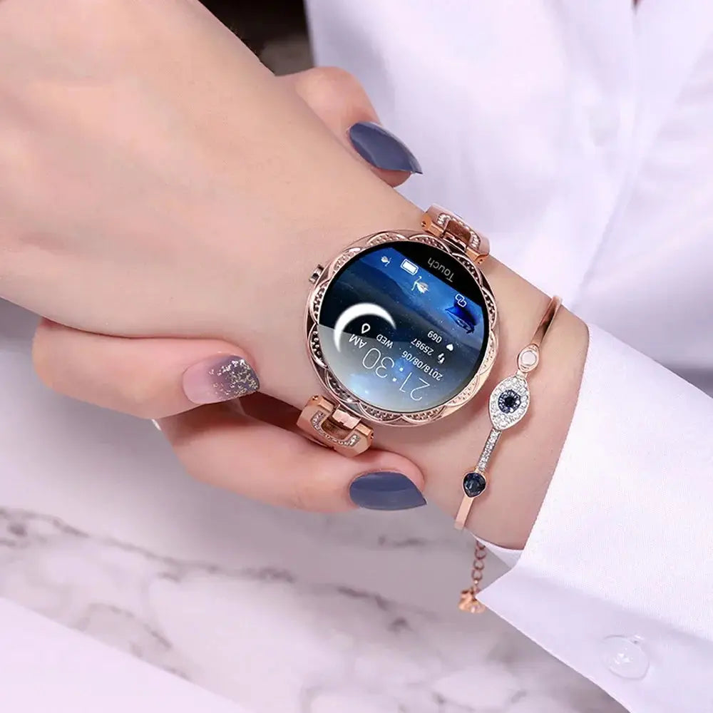 Arbaglobal women’s rose gold waterproof fitness smartwatch with circular face ornate bezel and illuminated time and date display