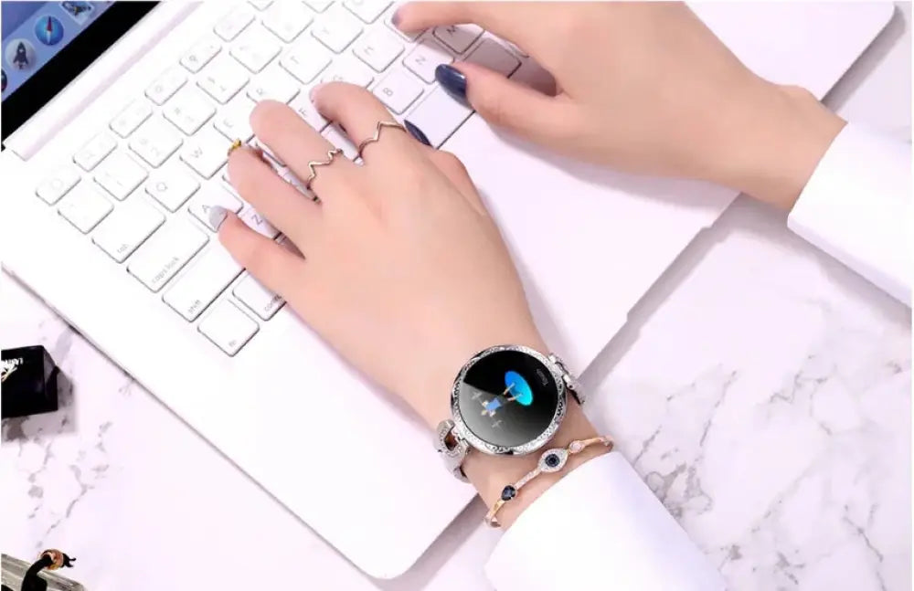 Arbaglobal women’s waterproof elegant fitness smartwatch with silver metallic bezel and black display showing blue design