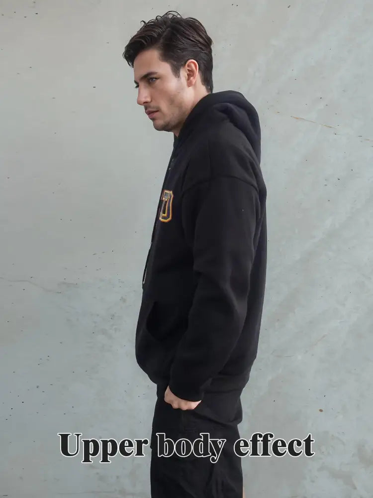 Black hoodie with gold and black embroidered logo on chest made of premium cotton for unisex streetwear