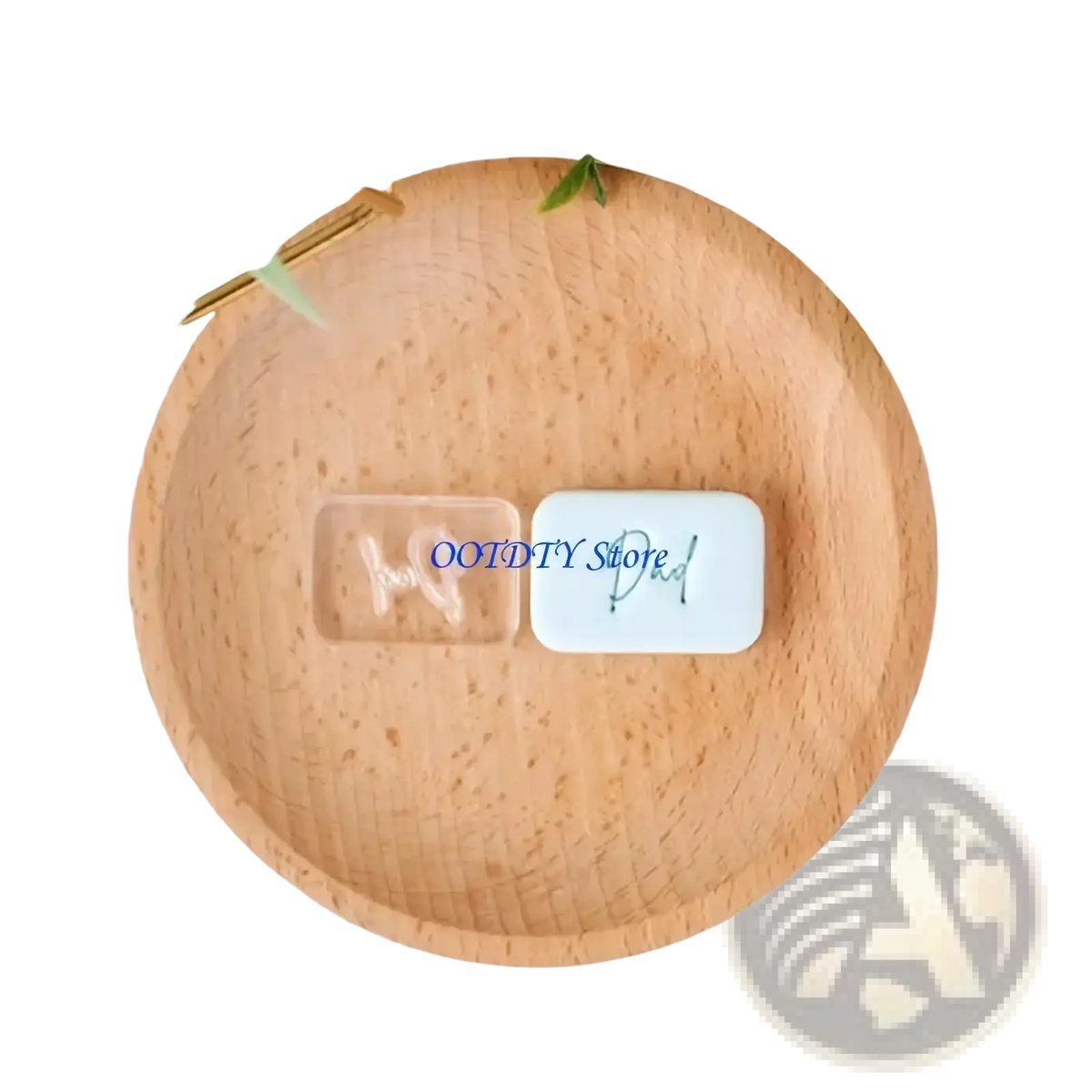 A clear rectangular resin father’s day charm with dad engraving and a white ceramic fondant stamp displayed on a wood plate