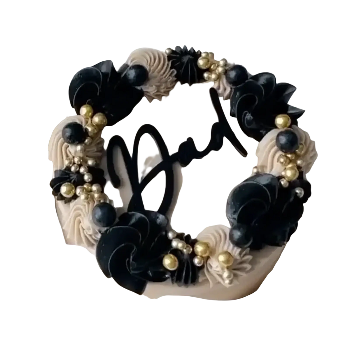 A round cake with beige frosting and black and gold edible flowers featuring a fathers day dad cake topper acrylic