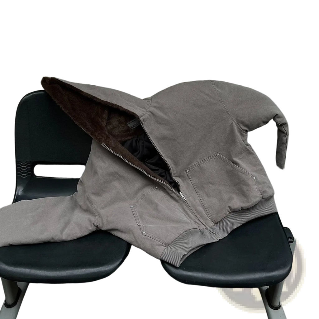 Beige faux fur lined cotton padded winter coat with brown fleece lining and silver zipper pulls on black bench