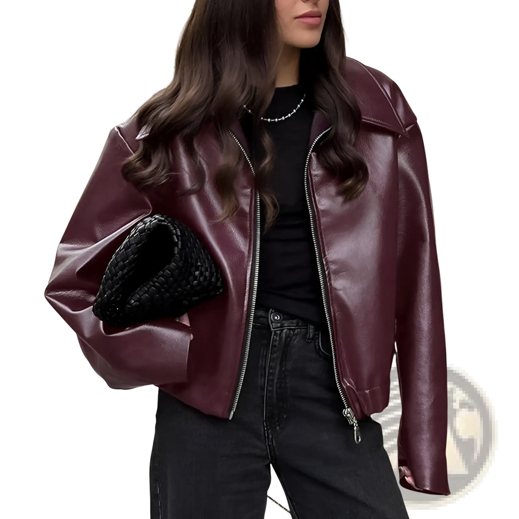 A glossy maroon faux leather cropped moto jacket with silver zipper detailing and loose fit bomber style