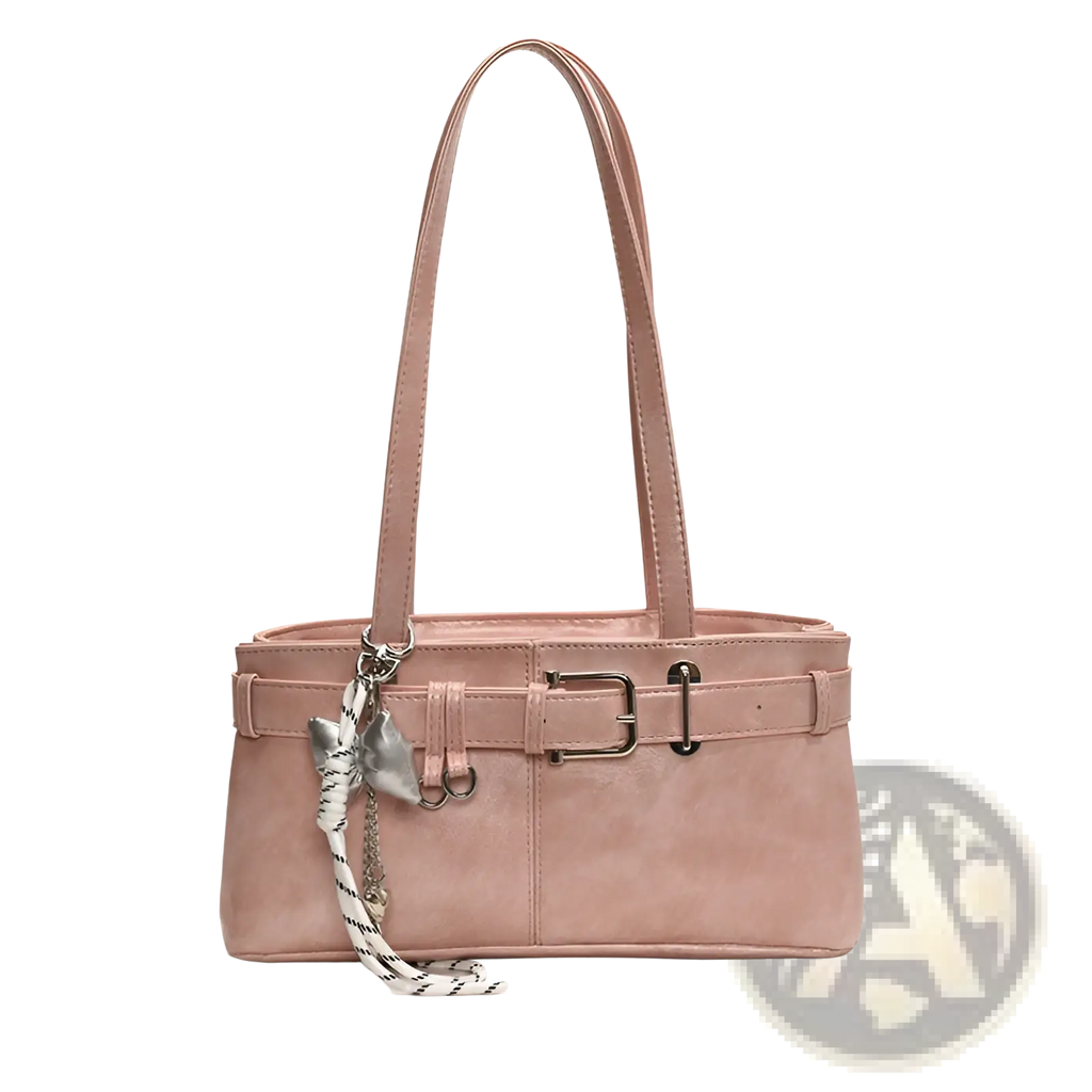 A blush pink faux leather buckle shoulder bag with belt-style closure and silver hardware featuring a bow charm