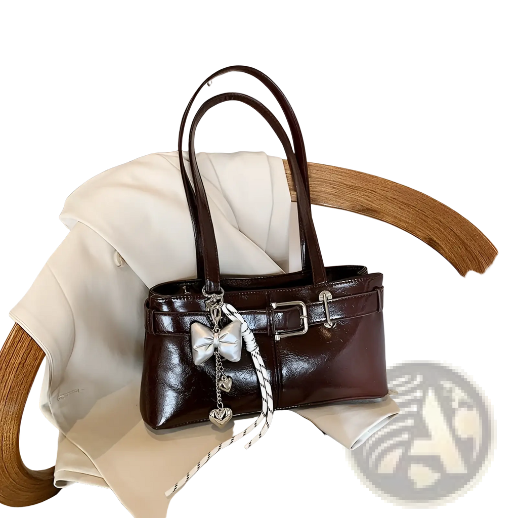Brown faux leather shoulder bag with silver buckle and decorative bow charm in patent leather finish