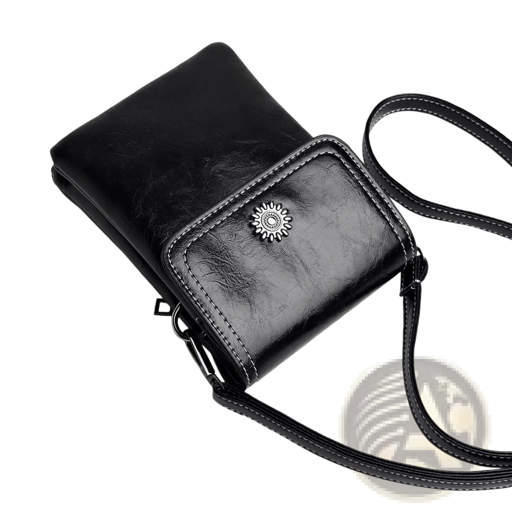 Black leather faux leather floral and sunburst crossbody phone bag with silver sunburst emblem and white stitching