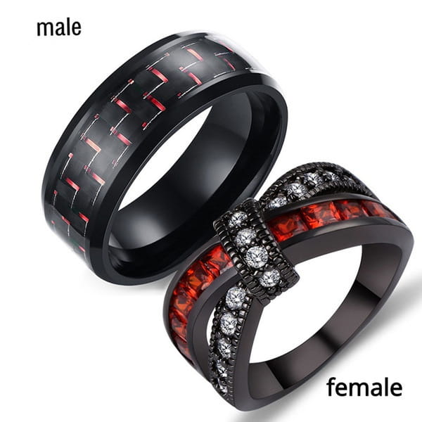 Black gold intertwined dragon ring set with black carbon fiber and red zircon gemstones designed as wedding bands for men and women.