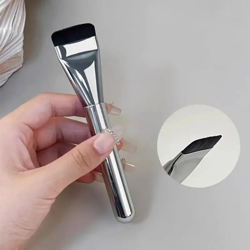 A sleek chrome-finished ultra thin foundation brush with a flat black-tipped head and a slender handle for traceless makeup application.