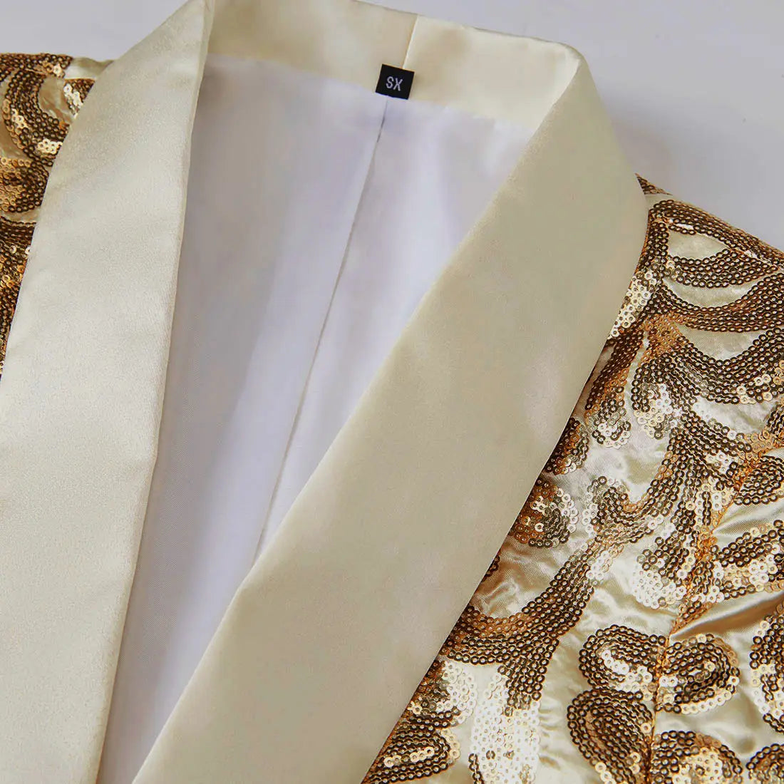 A gold sequin mens suit jacket with a shimmering sequined finish and a cream satin lapel and inner lining.