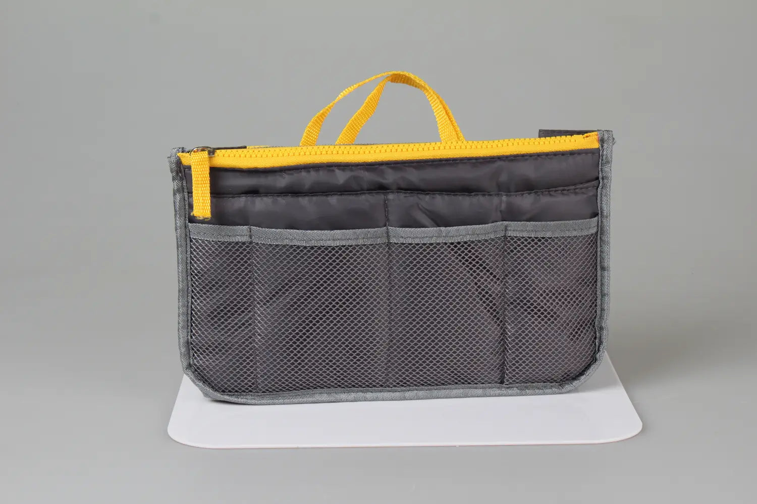 Gray mesh multi-pocket nylon handbag organizer with yellow dual zippers and handle designed for efficient bag storage.