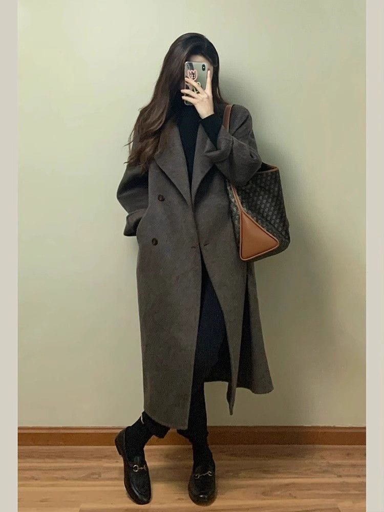 Ein langer dunkelgrauer Damen-Wollmantel mit doppelreihiger Knopfleiste, klassischem Design und breiten Revers.