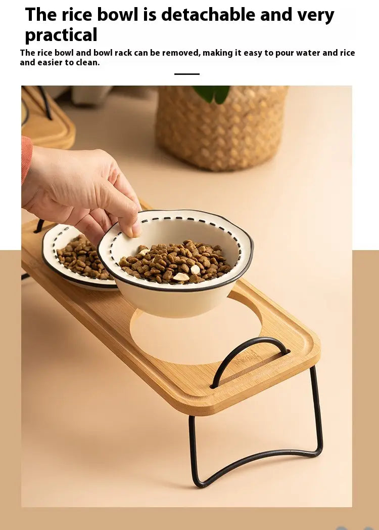 Elevated ceramic cat bowl with a white ceramic rice bowl featuring a black rim and dotted edge and a detachable design for easy cleaning set on a wooden stand.