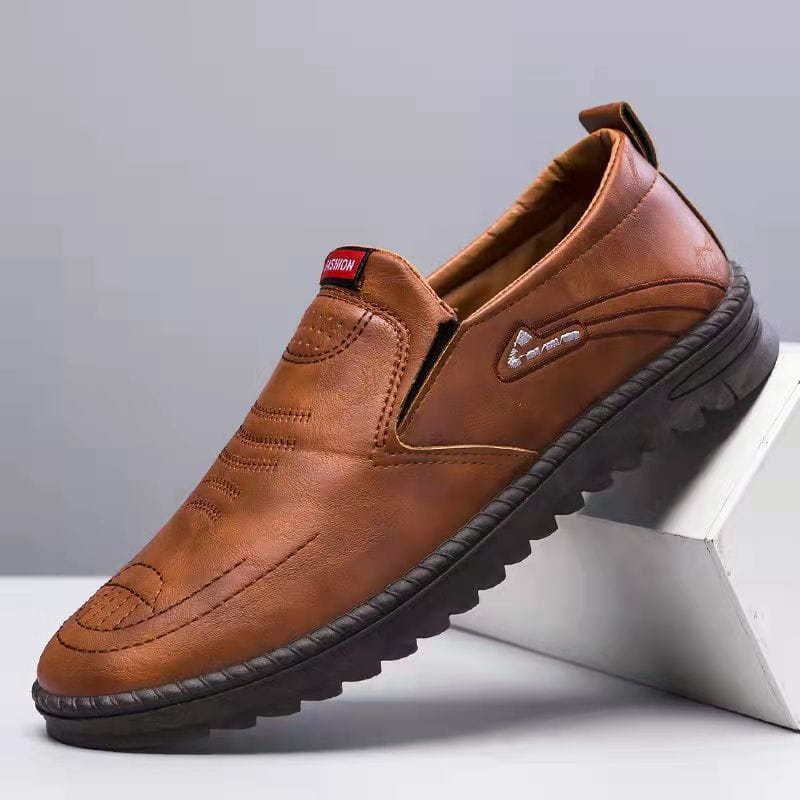 Men’s lightweight breathable white faux leather slip on shoe with brown embroidered detailing and textured rubber sole