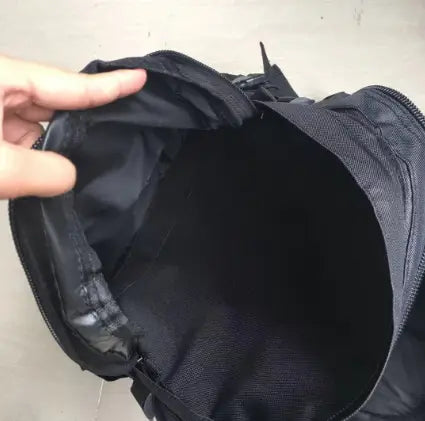Black nylon tactical camouflage mountaineering backpack for hiking with zipper opening and reinforced stitching.