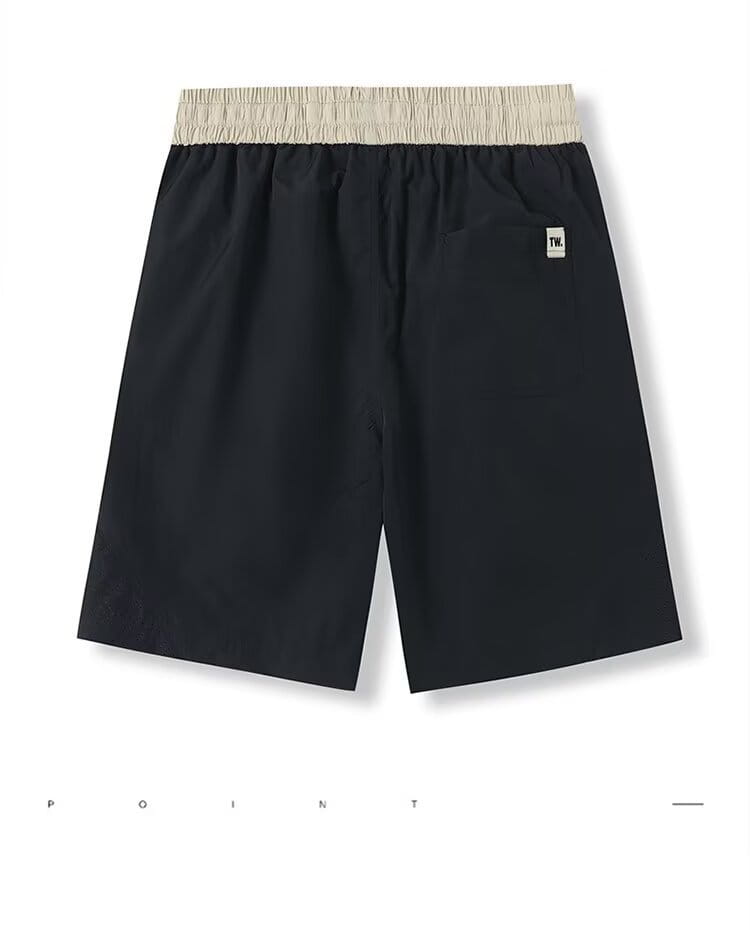 Shorts en nylon décontractés pour hommes, coupe droite, noirs, avec une ceinture élastique beige et un petit écusson de logo blanc sur la jambe inférieure droite.