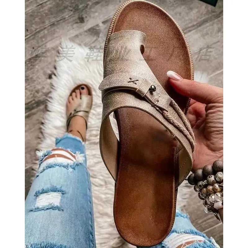 Women leather thong sandals casual flat platform slides in taupe textured leather with braided strap detail and small metallic buckle.
