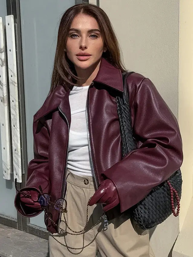 Eine edle weinrote Kunstleder-Bomberjacke mit klassischem Kragen und Frontreißverschluss, mit lockerer Passform und einem kurz geschnittenen Moto-Jacken-Stil.
