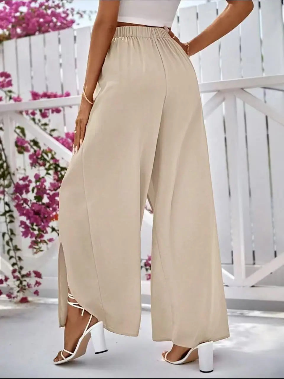 Beigefarbene, hoch taillierte Hosen mit weitem Bein, mit entspannter, fließender Silhouette und seitlichem Schlitz für den Casual-Bereich.