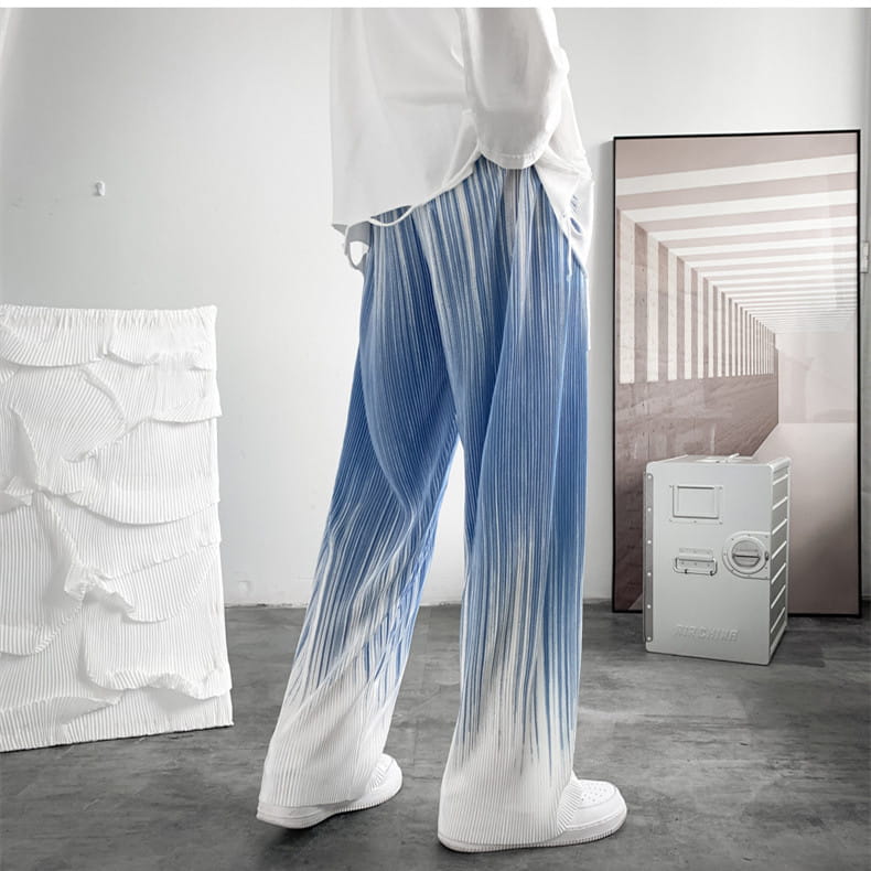Pantalons décontractés à jambes larges à plis en dégradé pour hommes dans des couleurs dégradées bleu et blanc, avec une coupe ample et un tissu souple.