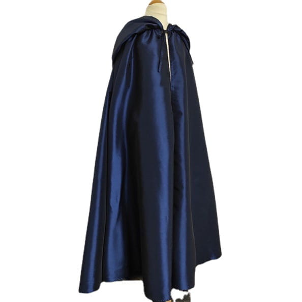 a deep navy satin cape with a soft flowing drape and gathered hood displayed alongside a wooden cat tree scratching post and condo