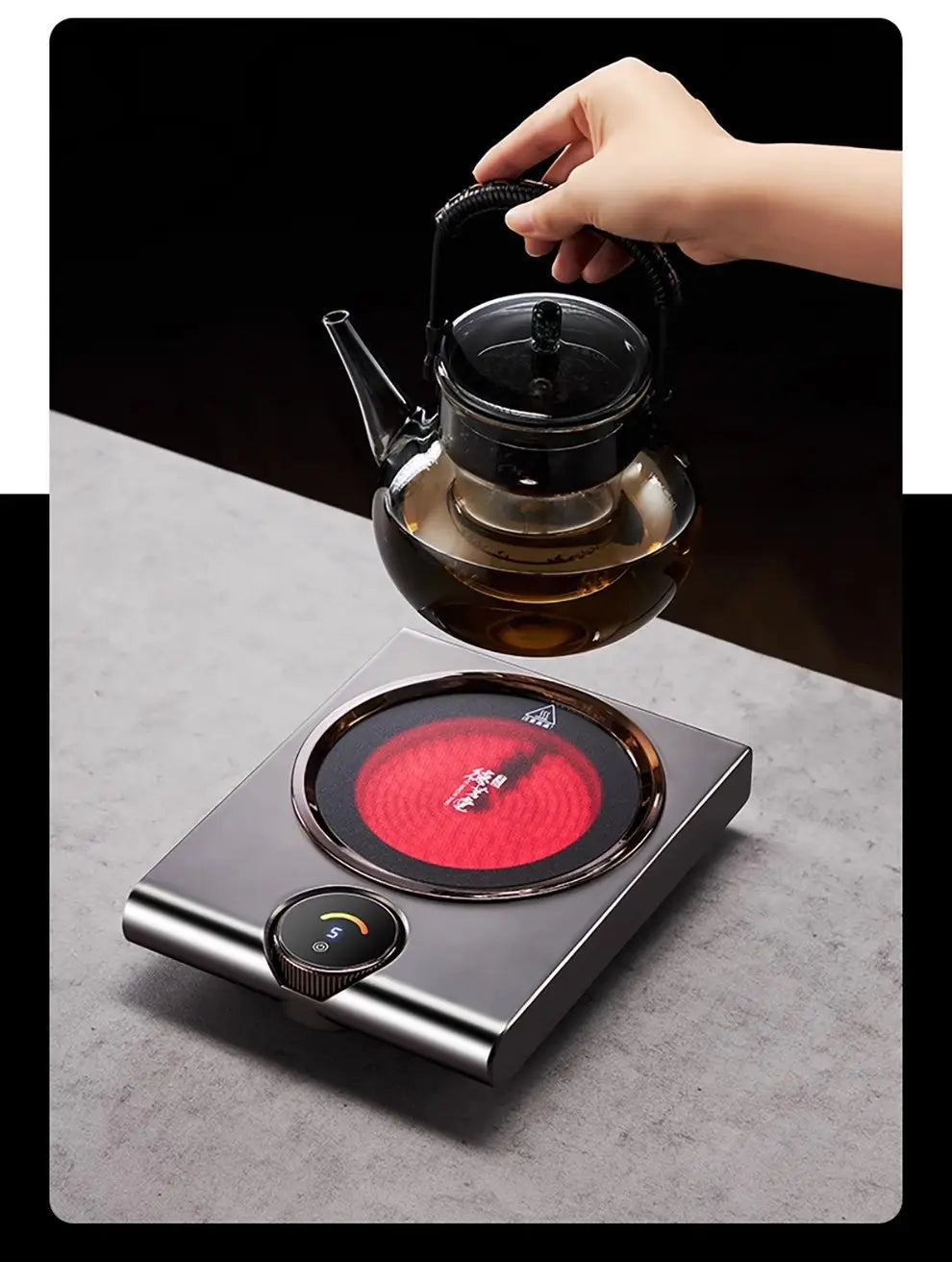 black glass teapot with metallic lid and handle resting on a sleek silver electric ceramic stove 1000w tea cooker kettle with a glowing red induction cooktop surface