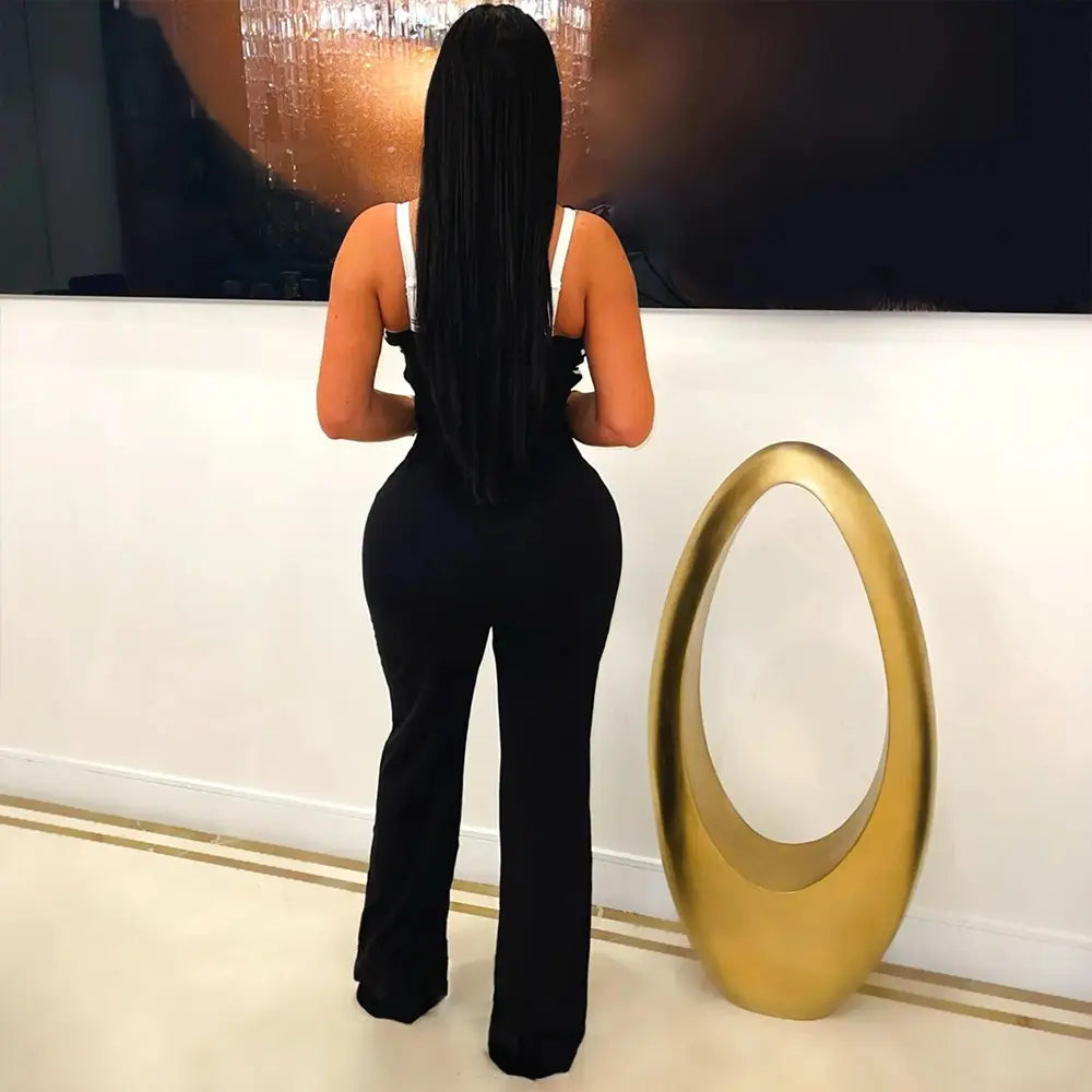 a gold oval-shaped sculpture with a hollow center and smooth reflective surface shown alongside a butterfly wing slim fit jumpsuit product.