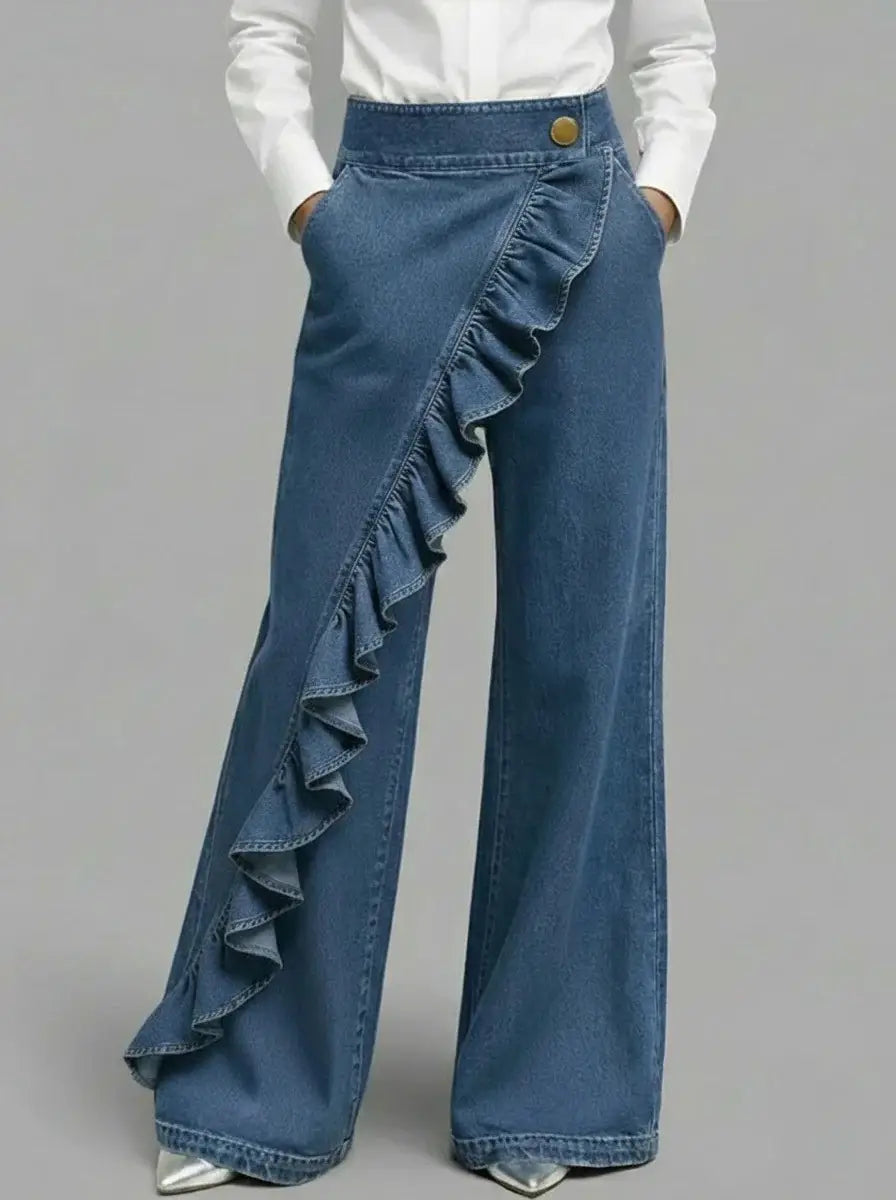 Pantalones de mezclilla azul de pernera ancha con volante de tiro alto, que presentan un detalle lateral con volante y un botón de tono dorado en la cintura.