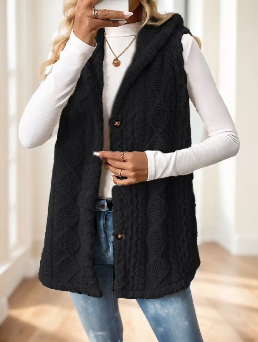 Schwarze Damen-Strickfleece-Weste mit Kapuze mit drei dunklen Knöpfen und einem warmen, strukturierten Design.