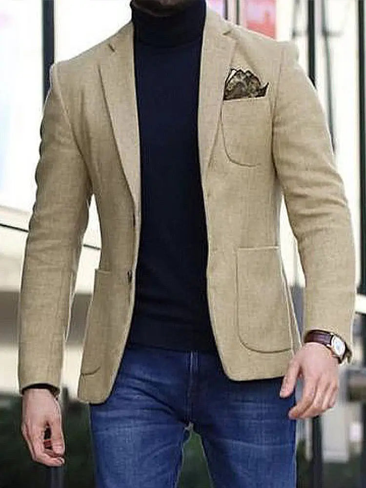 Beiger strukturierter Herren-British-Style-Casual-Blazer, mit dezentem Herringbone-Gewebe über einem schwarzen Rollkragenpullover getragen und mit blauen Jeans kombiniert.