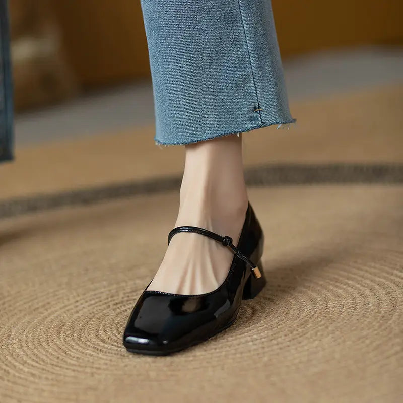 Black patent leather mary jane flats with a square toe and low block heel perfect for formal and casual wear.