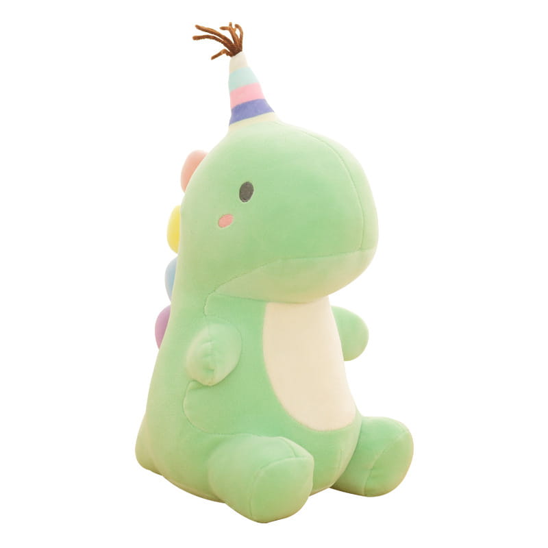 Ein weiches hellgrünes Dinosaurier-Plüschtier mit einer Regenbogen-gestreiften Party-Kappe mit braunen Quasten und farbigen Akzenten auf dem Rücken.