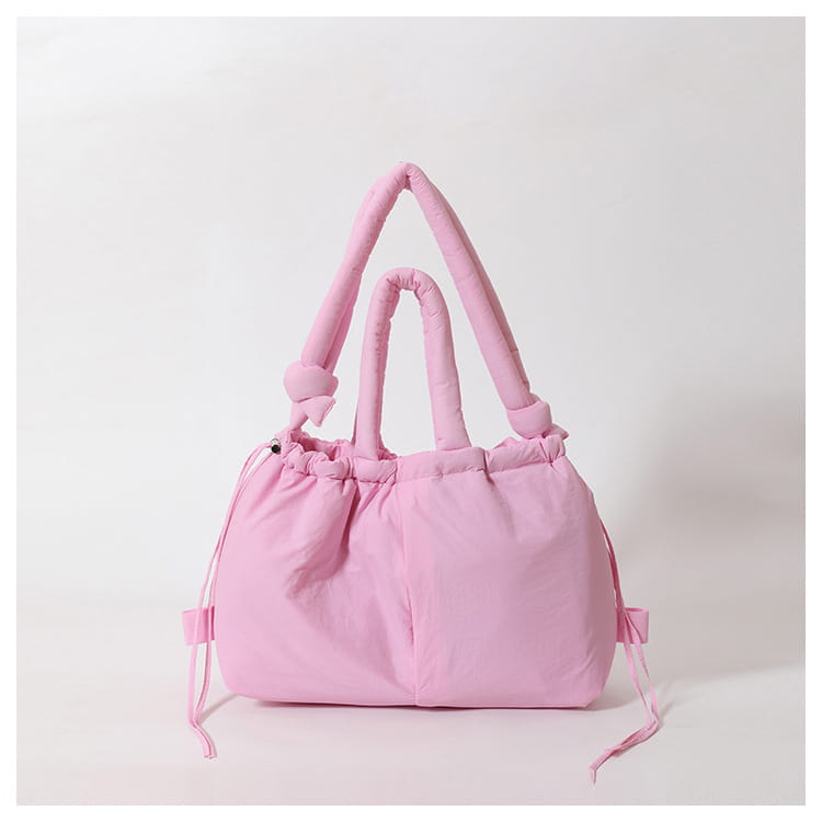 pink quilted puffer tote bag with plush quilted handles and drawstring closure made of lightweight nylon for shoulder use