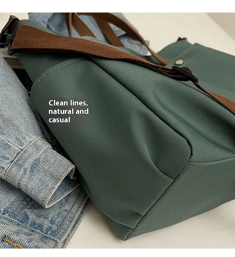 Olive green large capacity canvas tote bag with brown leather handles and a minimalist design.