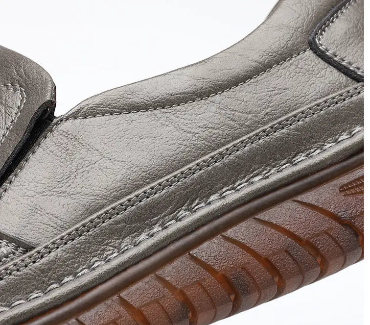 Men’s breathable non slip gray leather slip-on loafers with textured sole and visible stitching.