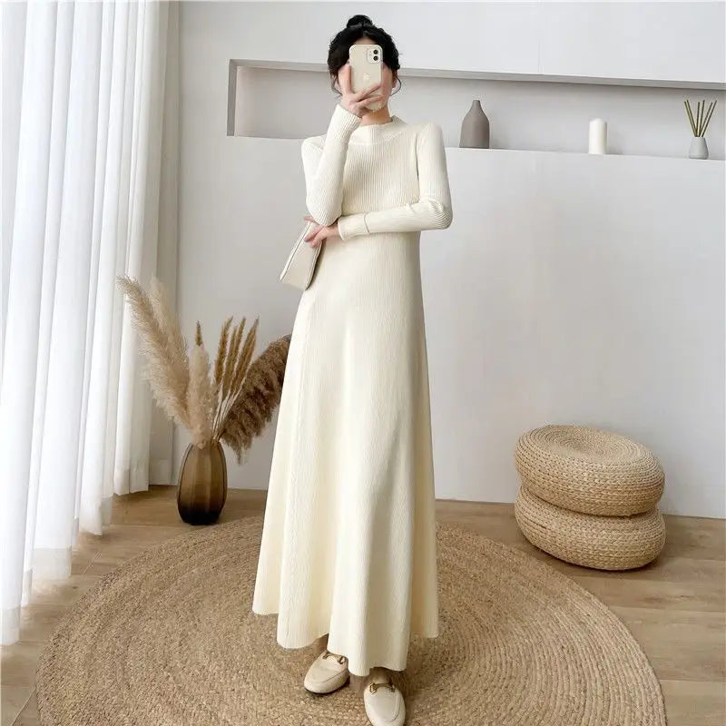 Robe midi en maille élégante à col montant et manches longues couleur crème, présentant un tissu en maille côtelée et une silhouette fluide.