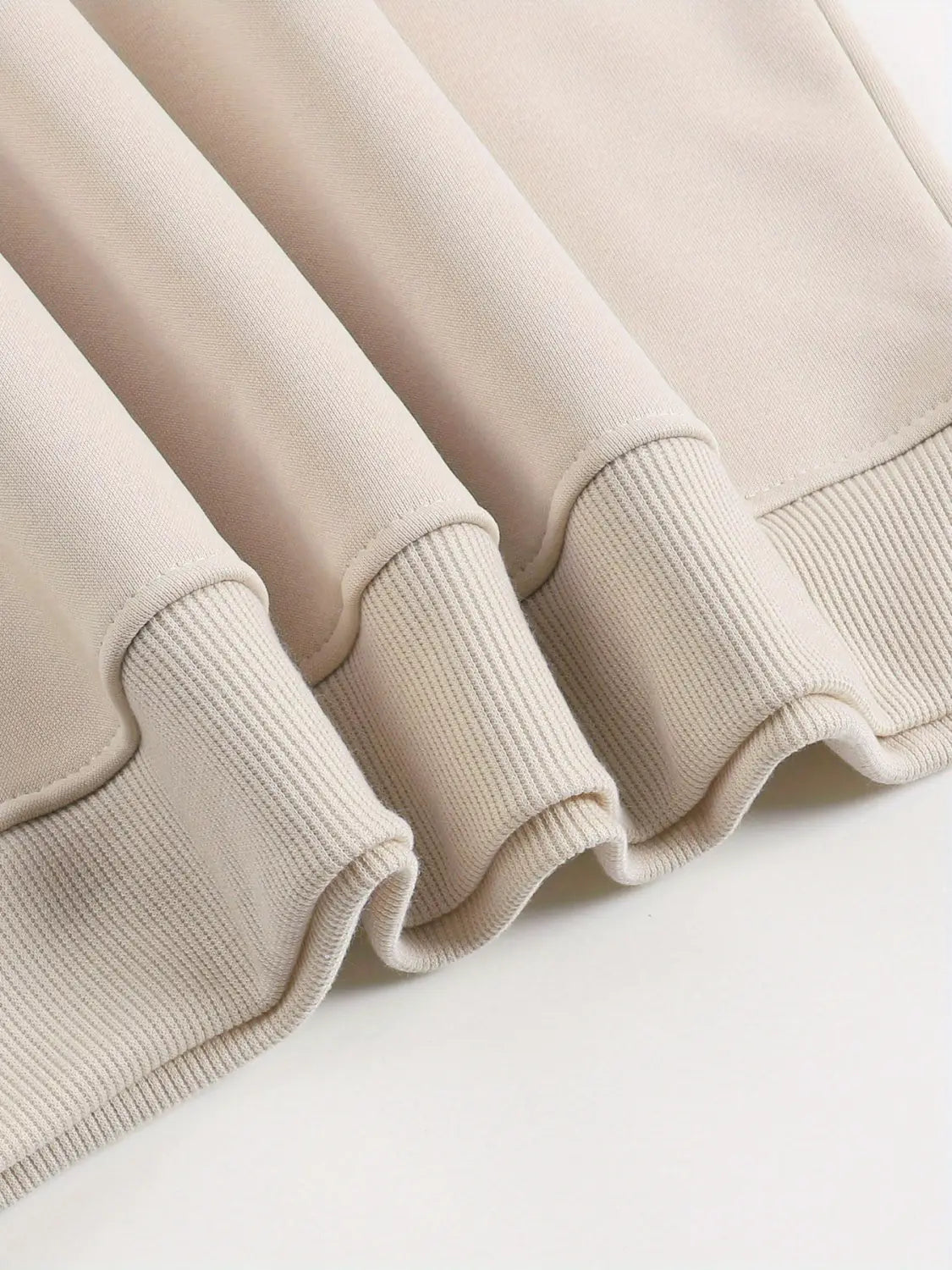 Sudadera extragrande crema con estampado peachy en color beige, con puños acanalados y tejido con textura suave.