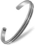 Silver-toned stainless steel cuff bracelet with intricate leaf pattern and textured geometric triangles along inner edge