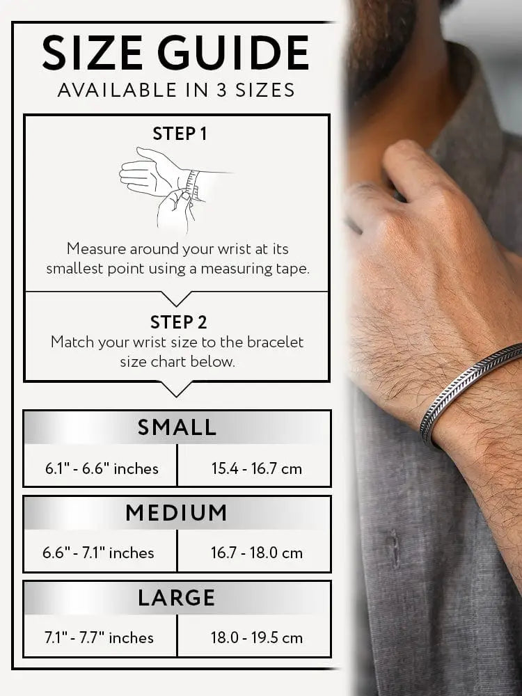 Silver-toned braided metal bracelet with intricate feather bone leaf pattern stainless steel cuff worn on mans wrist