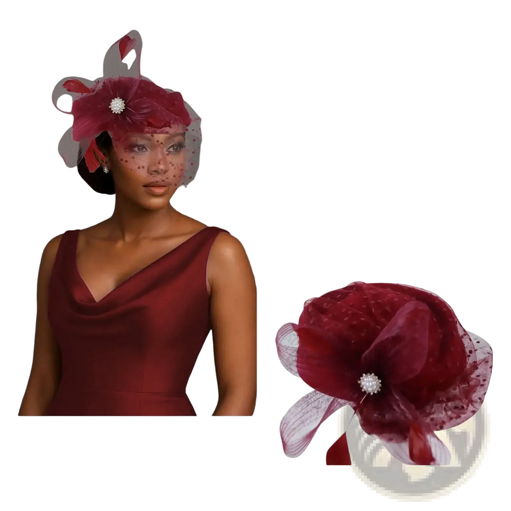 A maroon feather fascinator pillbox hat with a sheer mesh veil, rhinestone brooch, and ribbon accents for weddings