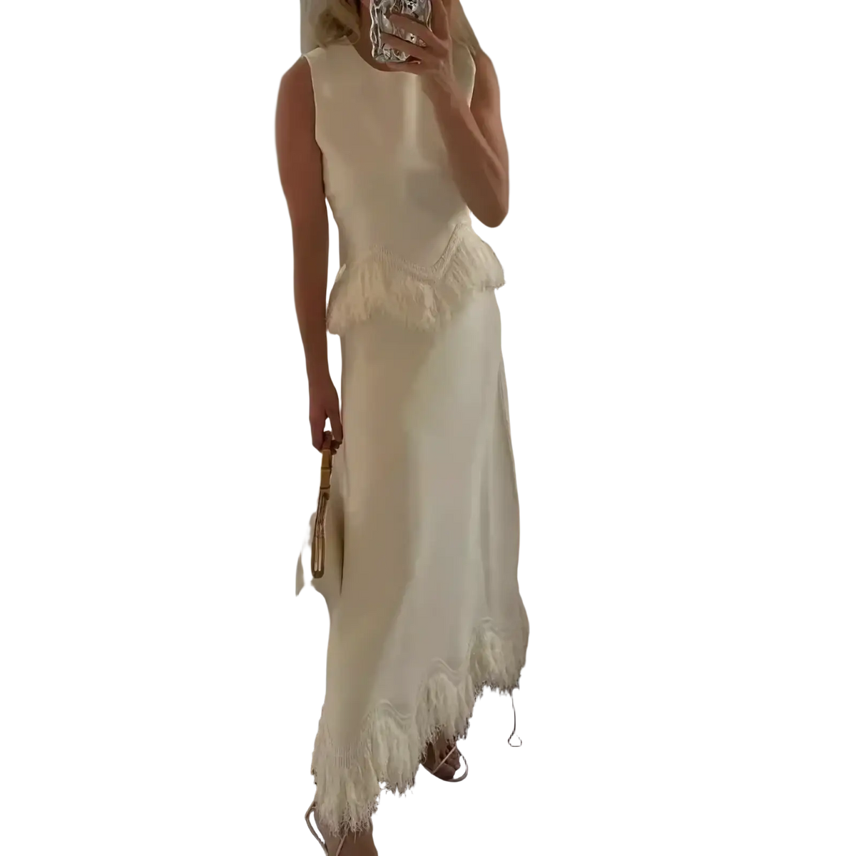 A flowing off-white sleeveless two piece maxi dress set with fitted bodice and feather trim asymmetrical hemline