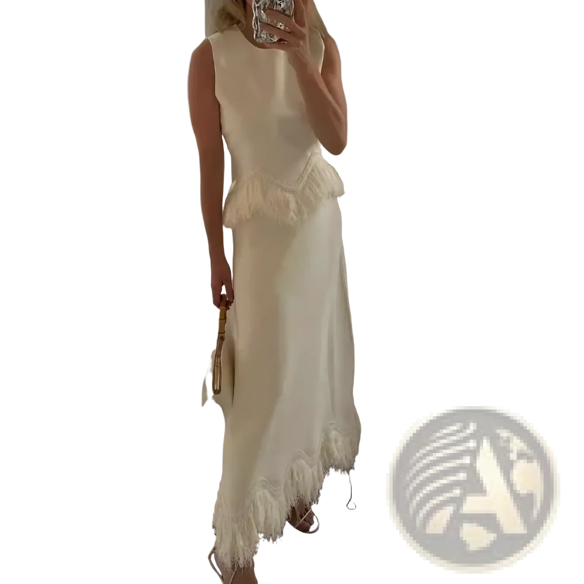 A flowing off-white sleeveless two piece maxi dress set with fitted bodice and feather trim asymmetrical hemline